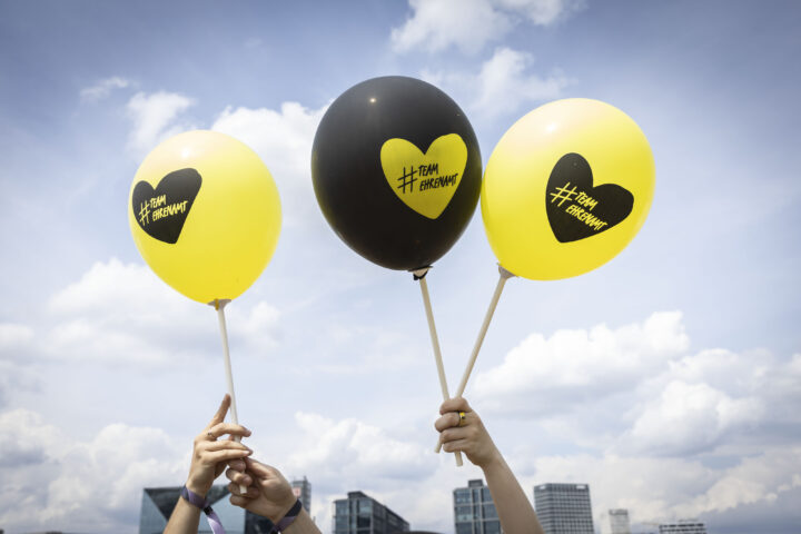 3 Luftballons mit der Aufschrift Hashtag Team Ehrenamt werden in die Höhe gehalten.